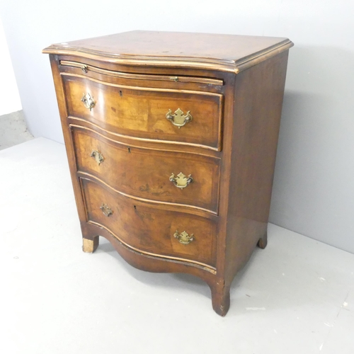 2575 - A crossbanded walnut and satinwood strung  serpentine chest of three drawers with brushing slide. 62... 