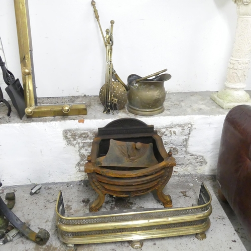 2613 - A cast iron fire grate, a brass fender, 81x22x23cm, a brass coal scuttle and a companion set.