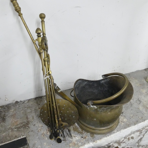 2613 - A cast iron fire grate, a brass fender, 81x22x23cm, a brass coal scuttle and a companion set.