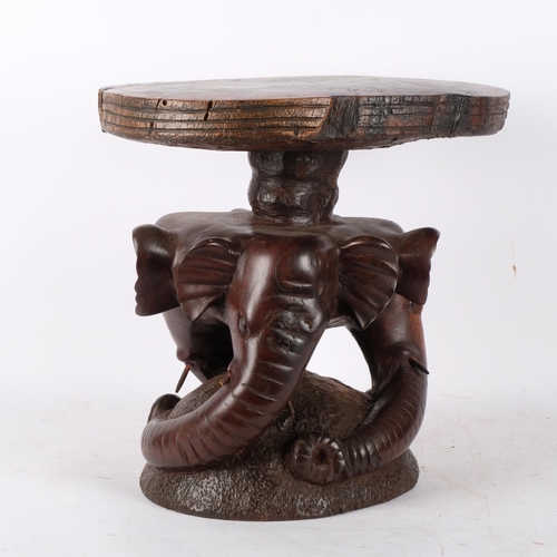 795 - A carved hardwood stool, supported by 3 carved elephant heads, 35cm