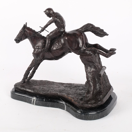 116 - A large patinated bronze group, a study of a horse and jockey over the jumps, on shaped marble base,... 