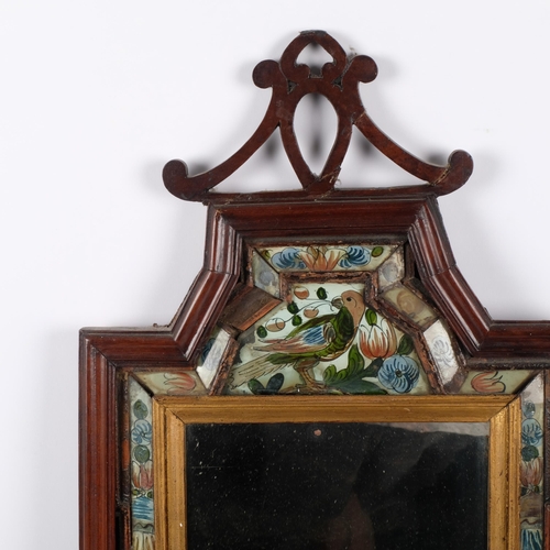 123 - A 19th Century mahogany-framed courting mirror, with a floral and bird painted glass cushion surroun... 