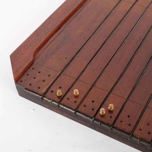 148 - An early 20th century shove ha'penny board, with hinged metal dividers, pegs and coins