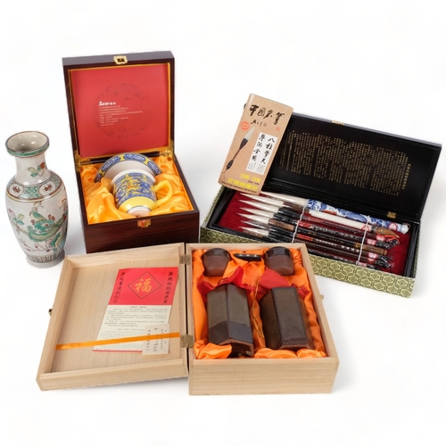 156 - A Chinese framed calligraphy brush set, reproduction crackle glaze vase, a sacer boxed cup and sauce... 