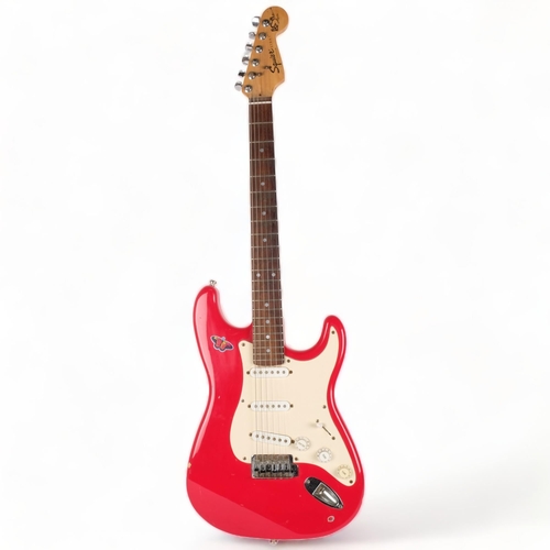 223 - A Squire Strat by Fender electric guitar, red body, serial no. YN732177, head is signed but unclear ... 