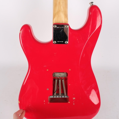 223 - A Squire Strat by Fender electric guitar, red body, serial no. YN732177, head is signed but unclear ... 