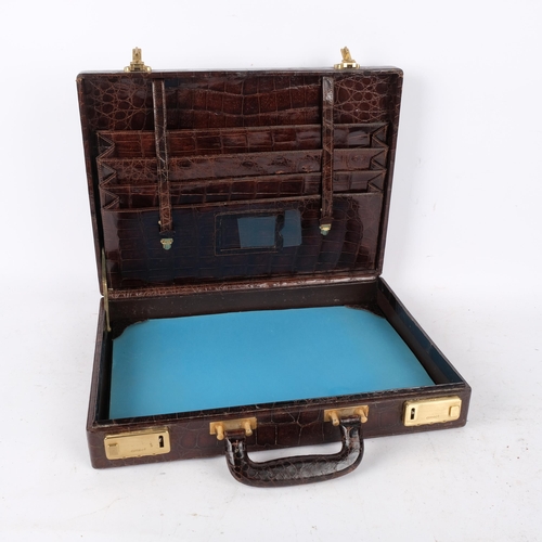 302 - A Vintage amuet crocodile skin briefcase, with fitted interior, blotter, and brass locks, 41cm acros... 