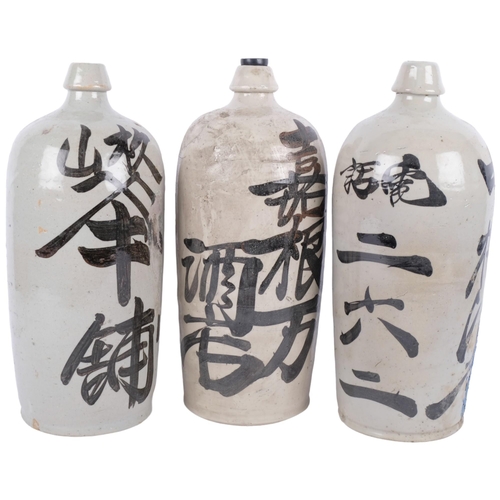 411 - 3 ceramic Japanese Sake bottles with inscriptions, 35.5cm