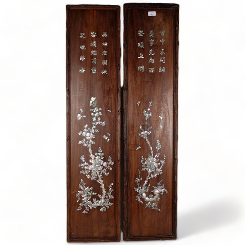 481 - A pair of Oriental hardwood panels, with inset mother-of-pearl script and blossom tree decoration, 1... 