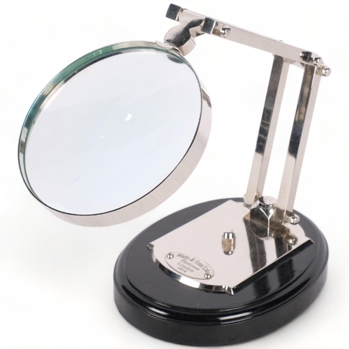 501 - A reproduction silver plated adjustable desk magnifying glass, on plinth, 12.5cm diameter