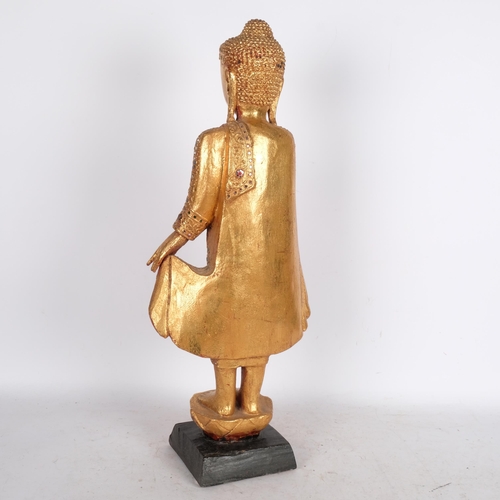 530 - An Oriental carved giltwood figure, with inset mirrored glass fragments, on carved wood plinth, H69c... 