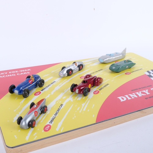 638 - A Dinky Toys table-top display, Dinky pre-war racing cars, mounted on wooden backboard, with various... 