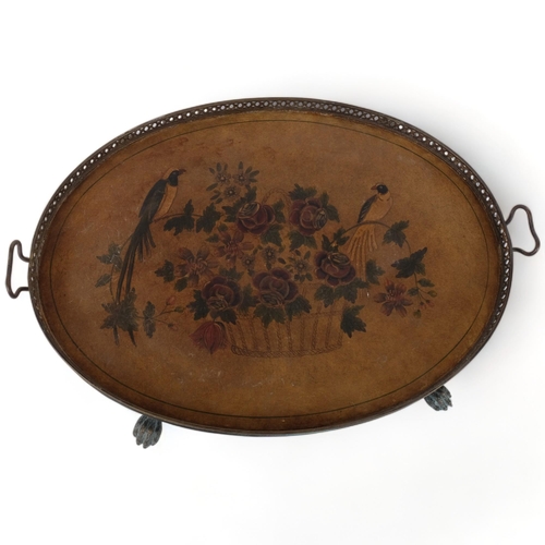 684 - An oval galleried tea tray on paw feet, with embossed and painted fabric panel depicting birds and f... 