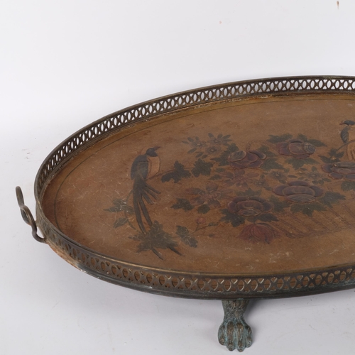 684 - An oval galleried tea tray on paw feet, with embossed and painted fabric panel depicting birds and f... 