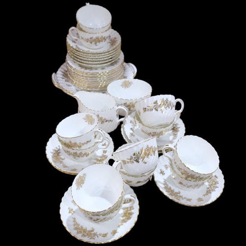 687 - A Minton gold and white fluted tea service, comprising 12 cups, 12 saucers, 11 side plates, 2 cake p... 