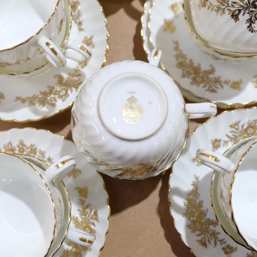 687 - A Minton gold and white fluted tea service, comprising 12 cups, 12 saucers, 11 side plates, 2 cake p... 