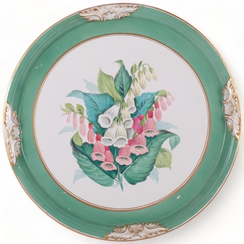 709 - A large hand painted charger, gilded rim and green outer border, with foxglove centre piece decorati... 