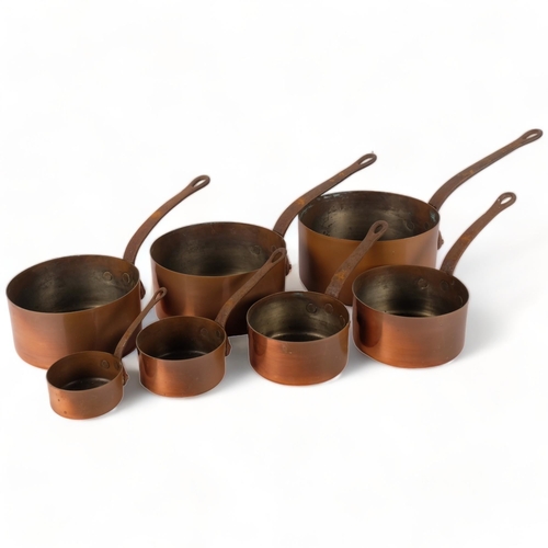 721 - A graduated set of 7 Vintage French copper saucepans, with cast-iron handles, largest 20cm diameter