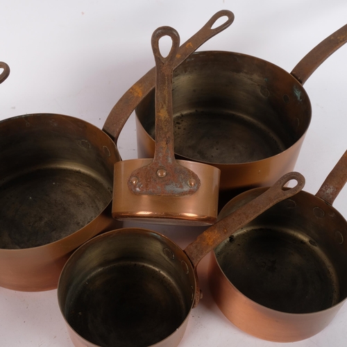 721 - A graduated set of 7 Vintage French copper saucepans, with cast-iron handles, largest 20cm diameter