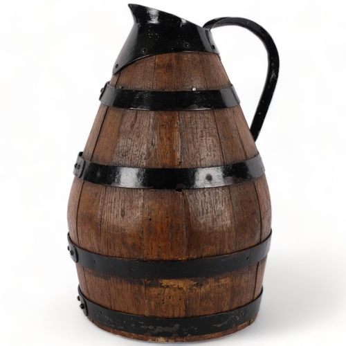 729 - A large coopered oak jug, with metal loop handle and spout, H46cm