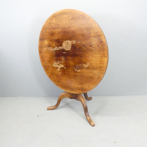 2692 - An antique oak circular tilt-top table on tripod base. 91x74cm.