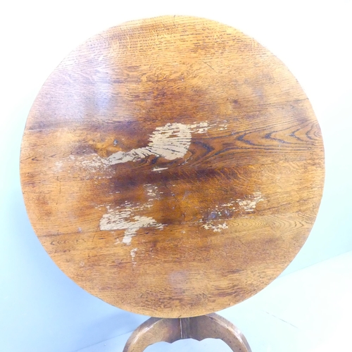 2692 - An antique oak circular tilt-top table on tripod base. 91x74cm.