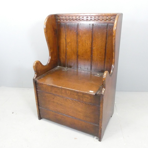 2696 - An antique oak settle with lifting seat. 61x92x42cm.