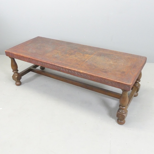 2708 - A leather covered mahogany rectangular coffee table, with tooled South American decoration. 129x42x5... 