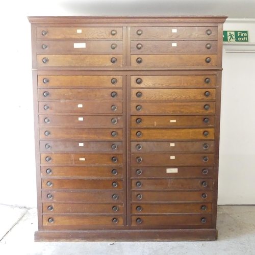 2716 - A large oak Apothecary's bank of thirty drawers with brass handles. 165x200x60cm.