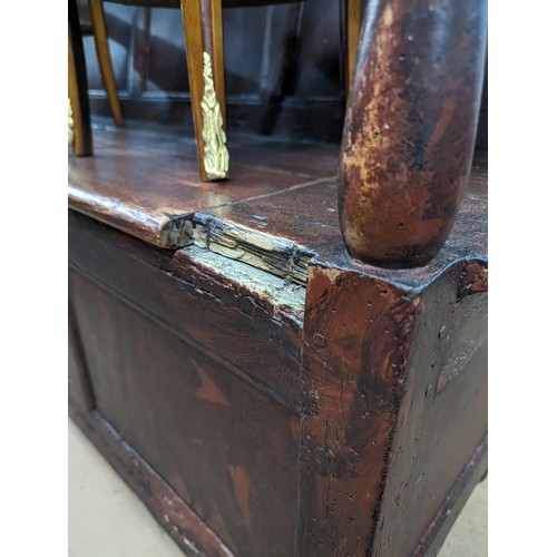 2184 - An antique stained pine settle, with panelled back and lifting seats. Overall 129x118x55cm, seat 116... 