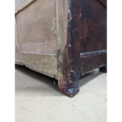 2184 - An antique stained pine settle, with panelled back and lifting seats. Overall 129x118x55cm, seat 116... 