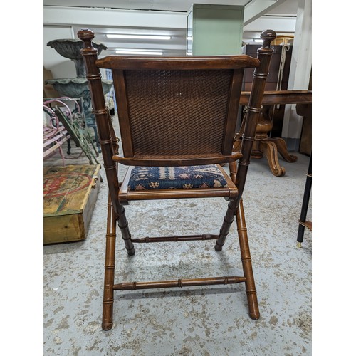 2729 - A pair of mahogany faux bamboo campaign style folding chairs with upholstered drop-in seats.