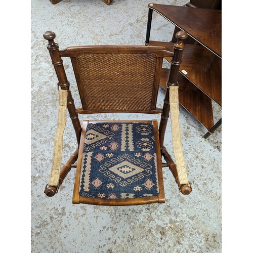 2729 - A pair of mahogany faux bamboo campaign style folding chairs with upholstered drop-in seats.