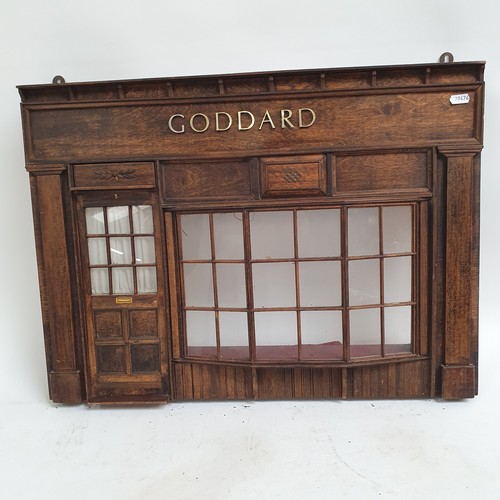 490 - A wall-hanging stained wood ornamental shop front, with glazed window and door panels 