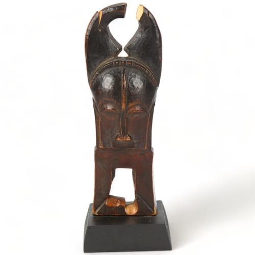 101 - A Baule, Ivory Coast weaving pulley, carved wood masked figure on wooden plinth, height 16cm