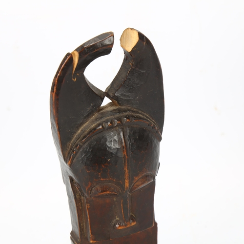 101 - A Baule, Ivory Coast weaving pulley, carved wood masked figure on wooden plinth, height 16cm