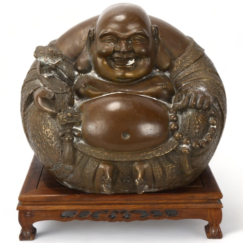 159 - A large Chinese bronze seated figure holding a sceptre, carved hardwood stand, overall height 36cm