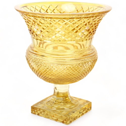 199 - A large cut amber glass Campana form table centre urn, with diamond-cut body on square base, height ... 