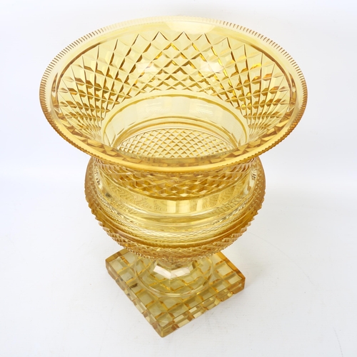 199 - A large cut amber glass Campana form table centre urn, with diamond-cut body on square base, height ... 