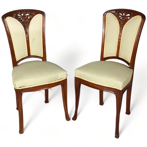 257 - A pair of French Art Nouveau walnut salon chairs, in the manner of Louis Majorelle, with relief carv... 