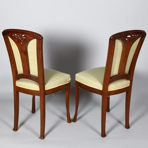 257 - A pair of French Art Nouveau walnut salon chairs, in the manner of Louis Majorelle, with relief carv... 