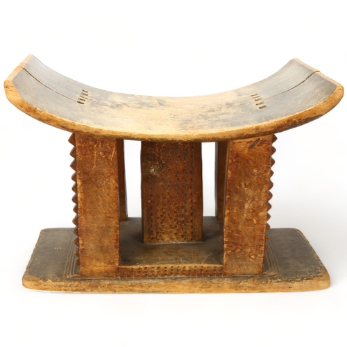 85 - An antique Ashanti stool, Ghana, with carved central column and supports, length 43cm, height 30cm