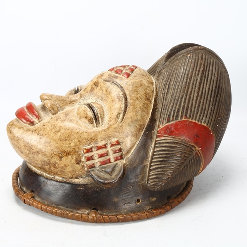 91 - A Punu, Gabon wood carved and painted female mask, with woven raffia border, height 30cm