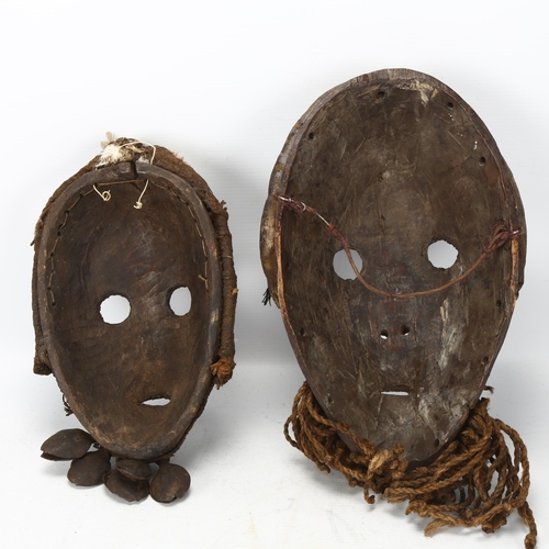 92 - Two African carved tribal masks, Dan, Ivory Coast, longest approx 34cm.