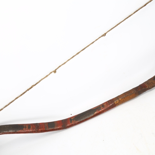 94 - A traditional Mongolian bow,  wood construction with painted chevron detail and leather strapping, l... 