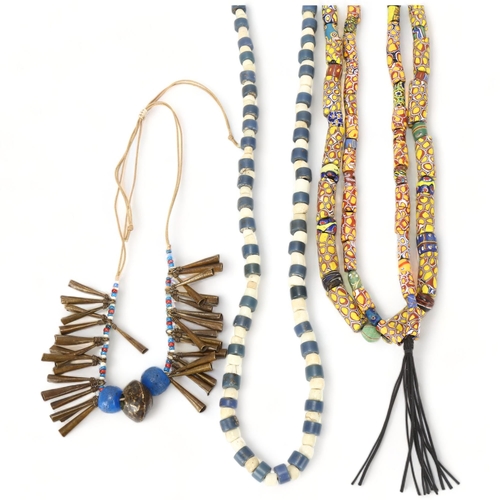 96 - Three strings of African tribal beads, glass millefiore, blue and white Ugandan beads and North Afri... 