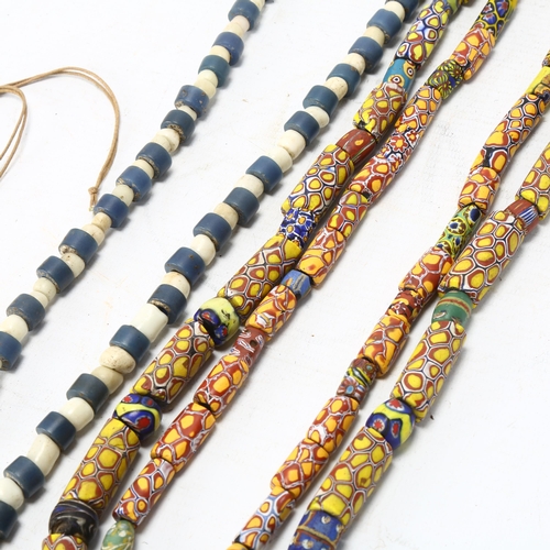 96 - Three strings of African tribal beads, glass millefiore, blue and white Ugandan beads and North Afri... 