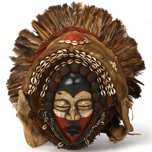 78E - A large Dan, Ivory Coast headdress, with feather and shell decoration, height approx 56cm