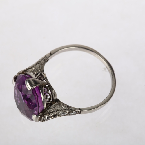 1111 - An Art Deco amethyst and diamond dress ring, claw set with oval mixed-cut amethyst and round-cut dia... 