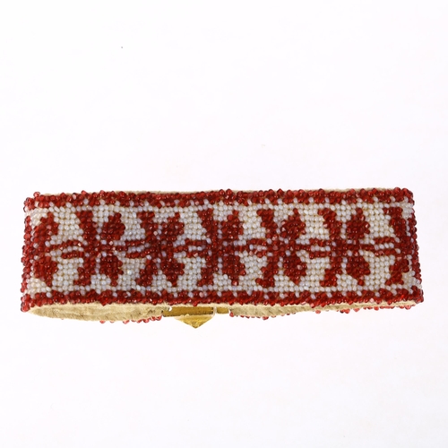 1134 - A Georgian garnet and glass beaded cuff bracelet, circa 1800, the gilt-metal floral clasp suspending... 